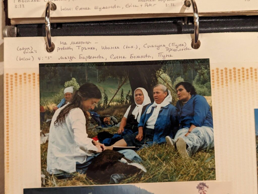 A picture of a photo album with a picture of a woman recording Bulgarian women outside